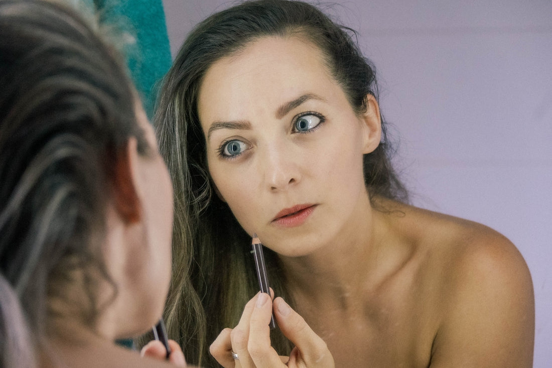 a woman is looking at her reflection in the mirror