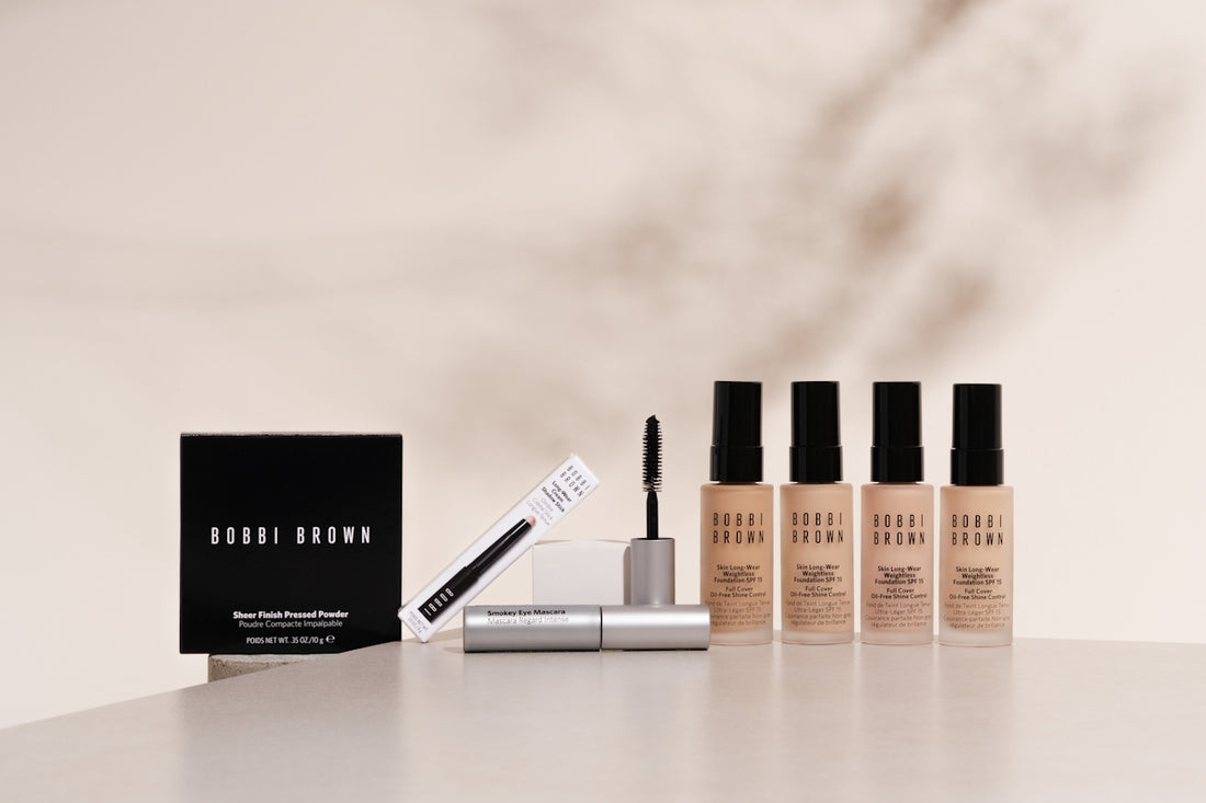 A white table topped with three bottles of makeup