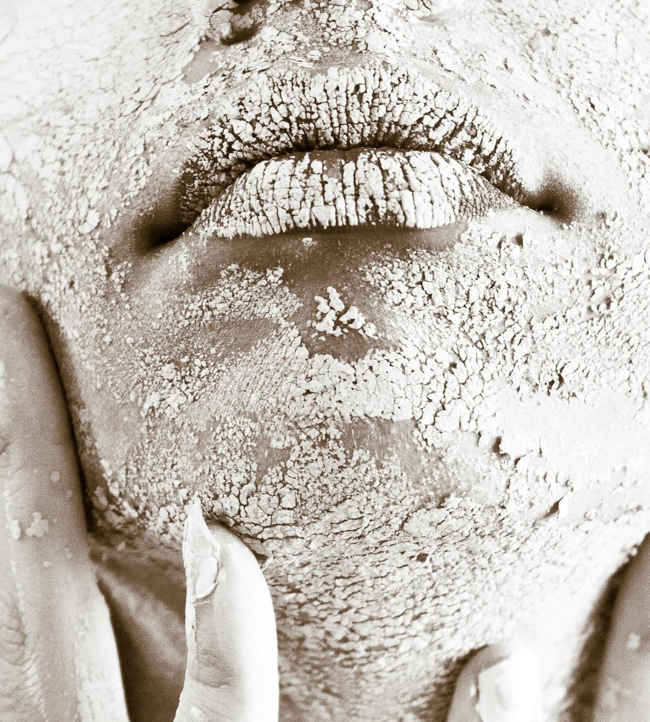 Close-up of a person's face with a textured, possibly clay-like surface.
